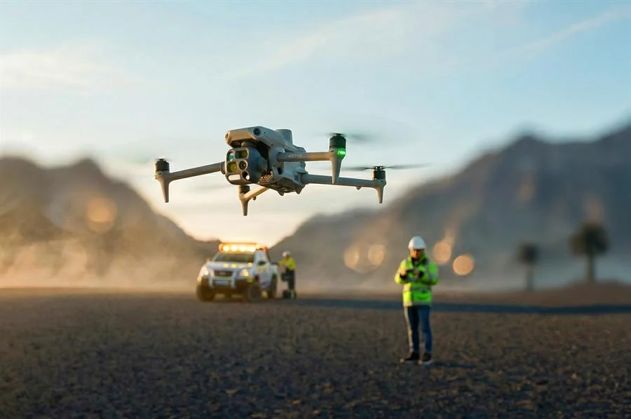 Drone surveying a desert field site with engineers